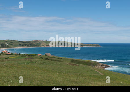 Ein Strand am Atlantik und Felder in der Nähe von Comillas in der Autonomen Kantabrien Gemeinschaft mit den Gipfeln Europas (los Picos de Europa in sp Foto Stock