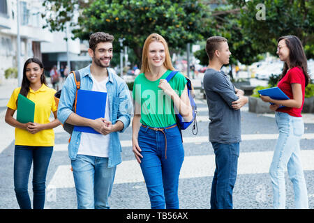 British studentessa e il brasiliano Guy con gruppo di studenti mutliethnic outdoor in città in estate Foto Stock