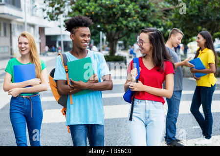 Il francese studentessa e ragazzo tedesco e un gruppo di studenti multietnica all'aperto in città in estate Foto Stock