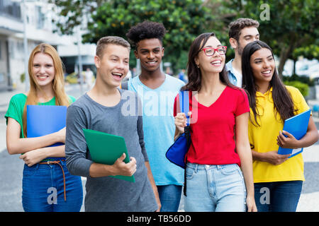 Il francese studentessa e ragazzo tedesco con un gruppo di studenti mutliethnic outdoor in città in estate Foto Stock