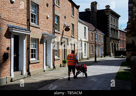 Portalettere sul suo giro di recapito di Howden, East Yorkshire, Inghilterra, Regno Unito Foto Stock