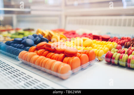 Assortimento di amaretti colorati su cafe vetrina. Varietà di sapori macaron. Dolce dolci di mandorla in negozio. Biscotti francesi. Foto Stock