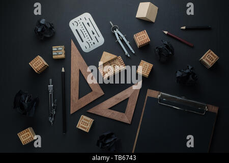 Costruzione casa, pianificazione e riparazione concetto. Blocco di legno home su una clipboard con attrezzature di ingegneria, bussole, righelli e matite. Il lavoro Foto Stock