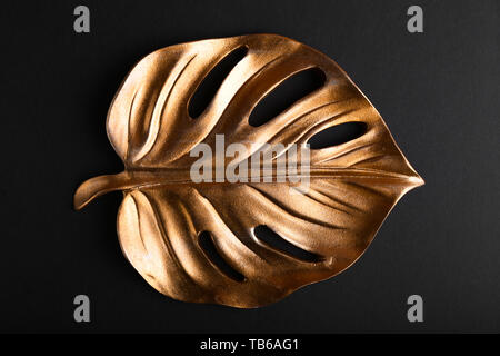 Golden foglia tropicale su sfondo scuro Foto Stock