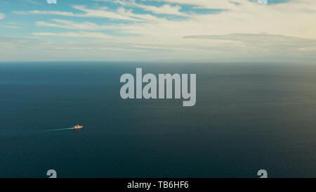 Piccoli traghetti passeggeri crociera in aprire il mare blu contro il cielo blu con nuvole, vista aerea. Seascape: assenger ferry boat in acque aperte FILIPPINE Mindanao Foto Stock