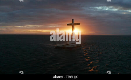 Croce cattolica nel cimitero affondata nel mare al tramonto, antenna fuco. colorato cielo durante il tramonto. Grandi crucafix segnando il sottomarino sunken cimitero, CAMIGUIN ISLAND Filippine. Foto Stock