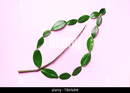 Layout creativi. Ecologia logo. Organici di foglia verde fatto di foglie su sfondo rosa. Lay piatto. Eco Friendly del pianeta e per uno sviluppo sostenibile per l'ambiente nozione Foto Stock