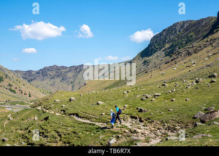 Walkers sulla parte del Allerdale escursione attraverso la valle Langstath, Borrowdale, Near Keswick, Cumbria, Parco Nazionale del Distretto dei Laghi UK in blue sk Foto Stock