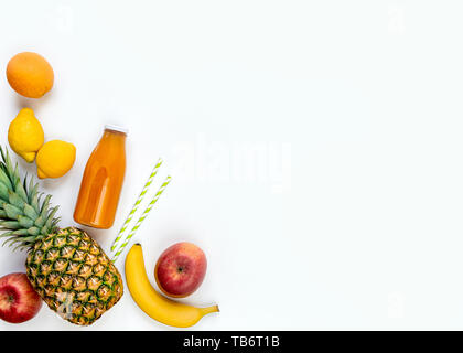 Vista dall'alto di frutta e una bottiglia di spremuta di succo multivitaminico su uno sfondo bianco. Copia dello spazio. Lay piatto. Foto Stock