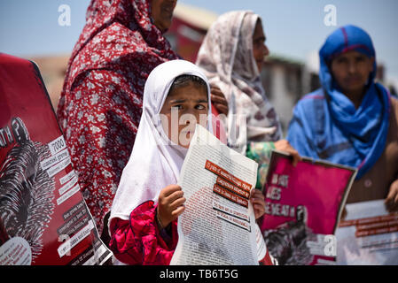 Una giovane ragazza, relativa di una persona scomparsa detiene una targhetta durante una manifestazione di protesta a Srinagar. La Associazione dei Genitori di Persone scomparse (APDP) è osservando la Settimana Internazionale della scomparsa, rinnovando la propria determinazione a lottare contro i fenomeni di sparizioni forzate in Jammu e Kashmir e richiamando la loro attenzione sulla relazione sulla tortura, rilasciato da Jammu Kashmir coalizione della società civile (JKCCS) e APDP. La relazione ha portato a concentrare l'uso sistematico della tortura contro il popolo di Jammu e Kashmir. Foto Stock