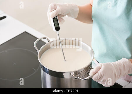 Donna preparando gustosi formaggi in cucina Foto Stock