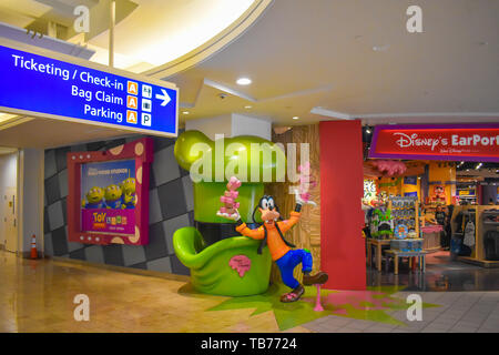 Orlando, Florida. Marzo 01, 2019. Biglietteria e informazioni sul Check-in segno e Pippo vicino al Disney Store all'Aeroporto Internazionale di Orlando . Foto Stock