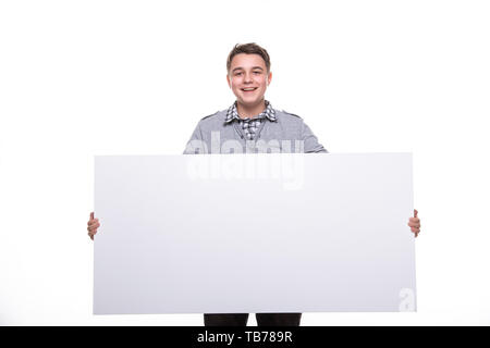 Close up uomo mostra pannello bianco. Ragazzo adolescente, studente, scolaro che mostra lo spazio vuoto Targhetta bianca. Foto Stock