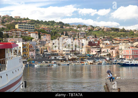 Aci Trezza Sicilia, panorama della città dal porto turistico, barche da pesca e il cielo sereno Foto Stock