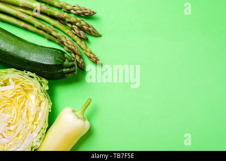 Verdure verdi su sfondo verde. Asparagi, zucchine, cavolo e peperone Foto Stock