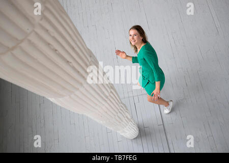 Studente di scultura Robyn Seabright prende uno sguardo più da vicino alla sua installazione dal titolo il consumo a media anteprima della Edinburgh College of Art grado show di Edimburgo. Foto Stock