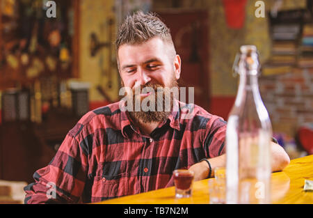 Brutale parigamba uomo barbuto sedersi al banco bar. Venerdì sera. Hipster rilassante presso il bar. Bar rilassante per avere bere e rilassarsi. Uomo con barba trascorrere il tempo libero a bere alcol forte. Bere per divertimento. Foto Stock