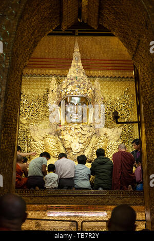 MANDALAY, MYANMAR - 25 gennaio: i fedeli si applicano le piazze di foglia oro al golden statua del Buddha a Mahamuni Paya tempio in Mandalay il 25 gennaio Foto Stock