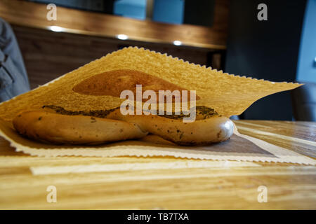 Pretzel nel pacco di carta su un tavolo di legno. Foto Stock