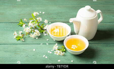 Una tazza di fiori profumati tè con petali su un sfondo di legno. Messa a fuoco selettiva. Copia dello spazio. Foto Stock