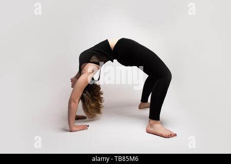 Flessibile isolato donna bionda facendo un ponte in classe di yoga. Uno stile di vita sano può essere miscelato con la meditazione. Copia dello spazio disponibile Foto Stock