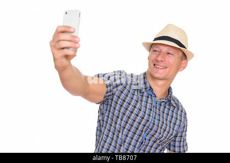 Studio shot di giovani felici uomo caucasico tenendo selfie isolata contro uno sfondo bianco Foto Stock