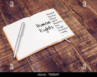Diritti umani il concetto di diritti umani mappa mentale con la scrittura a mano sulla nota prenota al tavolo di legno Foto Stock