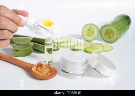 Organici skincare naturale concetto. Aprire blank crema cosmetica jar con crema bianca all'interno di texture e donne mano azienda contagocce in vetro per il dermatologo Foto Stock