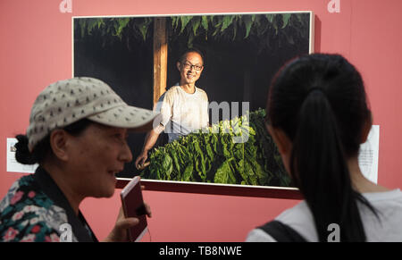 Pechino, Cina. 31 Maggio, 2019. Ai visitatori di visualizzare un lavoro di fotografia durante una mostra a tema di alleviamento della povertà in Cina il monumento del Millennio a Pechino Capitale della Cina, il 31 maggio 2019. Una mostra fotografica a tema di alleviamento della povertà ha dato dei calci a fuori il venerdì in Cina Monumento millenario. Circa 88 opere di fotografia sono in mostra fino a giugno 16. Credito: Cai Yang/Xinhua/Alamy Live News Foto Stock