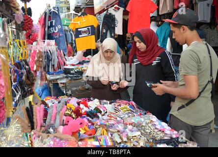 La striscia di Gaza. Il 30 maggio 2019. Palestinesi shop in un mercato a monte del Eid al-Fitr di Gaza City, 30 maggio 2019. I residenti nella Striscia di Gaza per cominciare la loro tradizione preparando ad accogliere le prossime Eid al-Fitr, la fine dei musulmani sacro mese del Ramadan. Gazans usato per andare a fare shopping negli ultimi giorni del mese del Ramadan per comprare i loro abiti, accessori e dolci. Ma questo anno è diverso da quello degli anni precedenti a causa delle difficili condizioni economiche. Per andare con 'Funzione: Ramadan la festa non felice a Gaza' Credit: Stringer/Xinhua/Alamy Live News Foto Stock