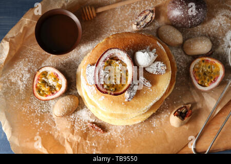 Gustosi pancake con il frutto della passione e i dadi su pergamena Foto Stock
