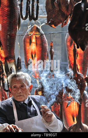 Lunyue, che ora è visibile solo in Lu Xun i romanzi, è completamente conservati in Anchang. In Anchang, il mercato antico lungo il fiume è pieno di pesci secchi, salame, sugo di anatra e di Lu Xun i romanzi. Semi-umana pesci verde appendere sotto il cornicione, il sole attraverso il pesce si asciuga la gioiosa rosso; in casa fatti a mano la salsiccia e sugo di anatra, naturalmente secco, salsa densa sapore permea l'intero mercato. Il locale vecchio uomo ha fatto una bella tazza di tè nel pomeriggio di sole e ha preso un pisolino. Ho consegnato una sigaretta e ascoltato il vecchio uomo raccontava la storia circa le usanze popolari di Anchang. Foto Stock