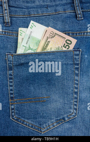 Vista ravvicinata di 100 euro e 50 dollari in banconote spuntavano da un jeans blu in tasca.