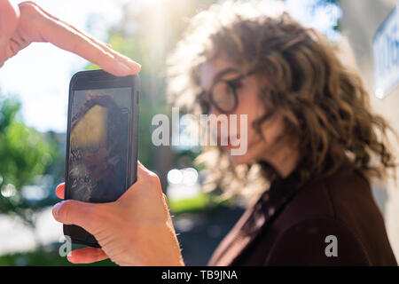 Amicizia, hygge e concetto di tecnologia - felice giovane donna prendendo la foto del suo amico tramite smartphone a casa Foto Stock