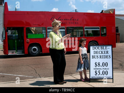 Un turista ricorda le attrazioni a sua figlia come essi attendere per un double-decker in autobus in Columbus, Mississippi. Foto Stock