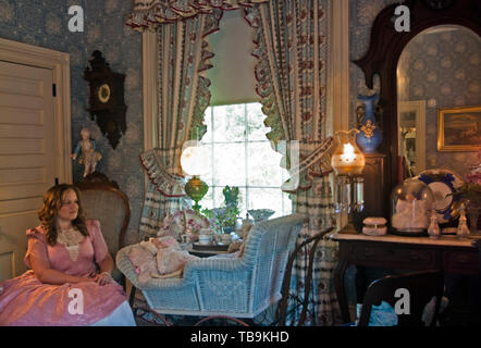 Una donna siede accanto a un presepe d'epoca nella "Blue Room" a Rosewood Manor, nota anche come Sykes-Leigh House, a Columbus, Mississippi. Foto Stock