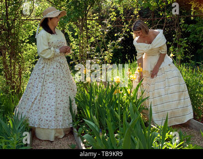 Le donne in abiti anteguerra passeggiata attraverso il giardino a colonnato, una storica casa in Columbus, Mississippi. Aprile 17, 2010. Foto Stock