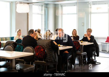 La città di New York, Stati Uniti d'America - Aprile 6, 2018: Manhattan NYC costruzione di midtown Herald Square Courtyard Marriott hotel con gente seduta di consumare la colazione in r Foto Stock