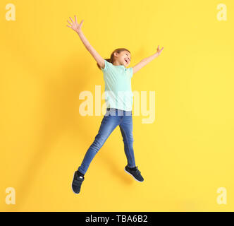 Jumping bambina sul colore di sfondo Foto Stock