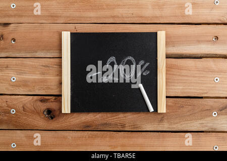 Chalk Board con l iscrizione -20 percento su un sfondo di legno. La vista dall'alto Foto Stock