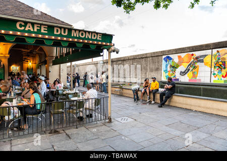 New Orleans, Stati Uniti d'America - 22 Aprile 2018: la gente in linea di attesa in coda per entrare Cafe Du Monde ristorante segno beignet mangiare lo zucchero in polvere di ciambelle e chicor Foto Stock