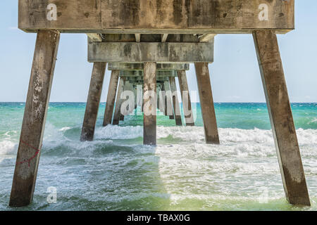 Sotto sotto Okala pesca del molo a Fort Walton Beach, Florida con pilastri, verde ondulazioni in Panhandle, Golfo del Messico in estate da sole Foto Stock