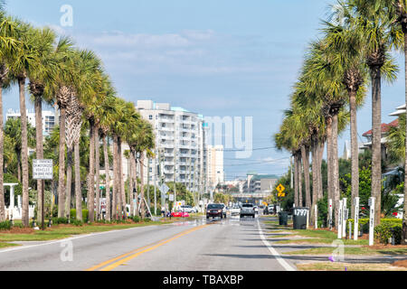 Destin, Stati Uniti d'America - 24 Aprile 2018: Strada in Miramar Beach City town con condominio appartamento condominio edifici, alberi di palma e di automobili in estate, Florida Foto Stock