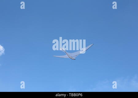 Un aquilone nella forma di un unico grande uccello bianco. Un aquilone in Cielo tra le nuvole. Grande Uccello bianco nel cielo. Foto Stock