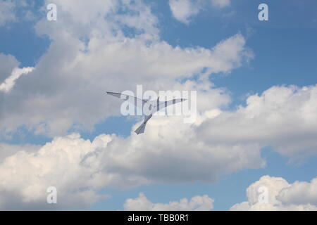 Un aquilone nella forma di un unico grande uccello bianco. Un aquilone in Cielo tra le nuvole. Grande Uccello bianco nel cielo. Foto Stock