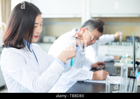 Persone che fanno di esperimento di chimica in laboratorio moderno Foto Stock