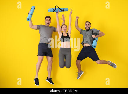 I giovani sportivi jumping contro il colore di sfondo Foto Stock