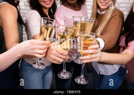 Close-up di donne per festeggiare un addio al nubilato di partito e tintinnanti bicchieri da champagne Foto Stock