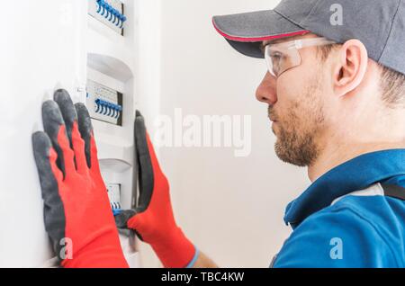 Elettricista tecnico al lavoro in una zona residenziale di impianto  elettrico utilizza la pinza spelafili con le mani protette da guanti Foto  stock - Alamy