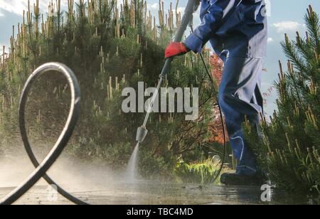 Giardino Percorsi di lavaggio di potenza utilizzando la rondella a pressione. Manutenzione del cortile. Foto Stock